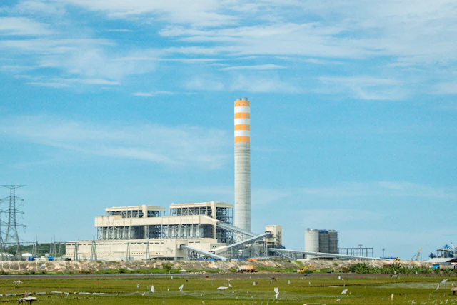 German industrial power plant with smokestacks against cloudy sky during energy crisis